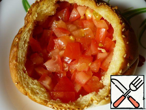 Make a cross-shaped incision on the tomato, scald it with boiling water, peel it off and chop finely.
Place the tomato pulp in our bun.  Salt.