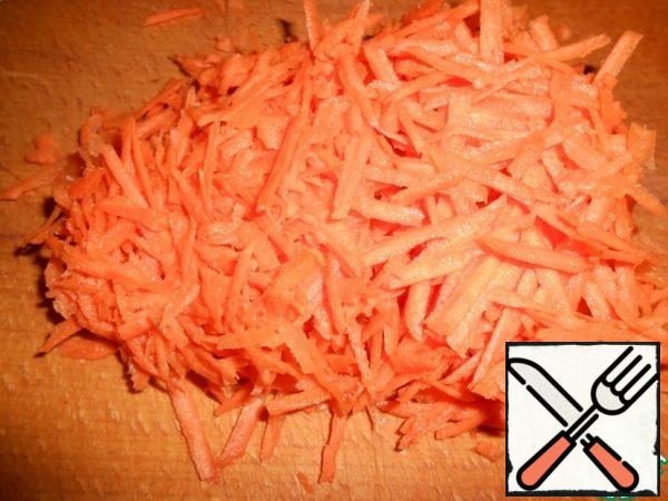 Three carrots on a large grater.
