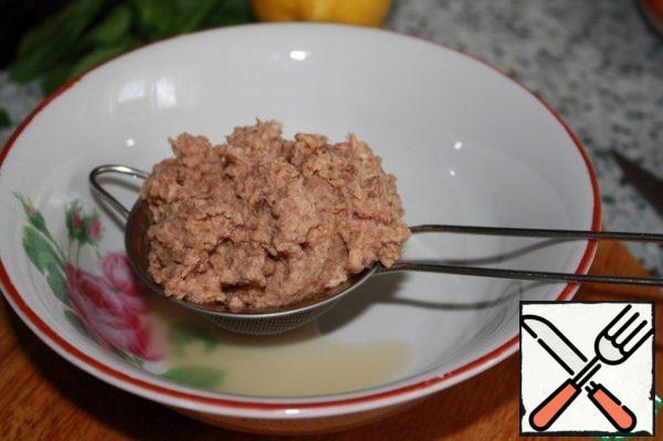 Drain the excess liquid from the tuna can.