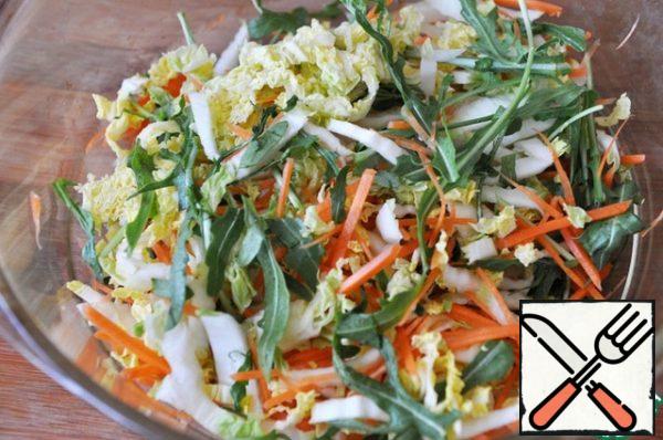 Add arugula to the cabbage and carrots, you can add any salad mix and herbs as desired.
