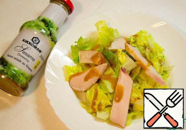 Large slices of chicken casually cover the salad.