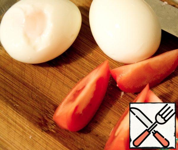 Cut the eggs and tomatoes into half-moons and put them on plates.