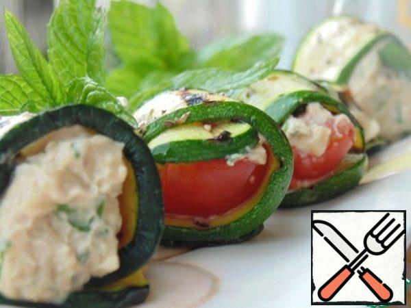 Assemble the rolls: put 1 tsp of cheese filling and a slice of tomato on each plate of zucchini and wrap it in rolls. Cool in the refrigerator.