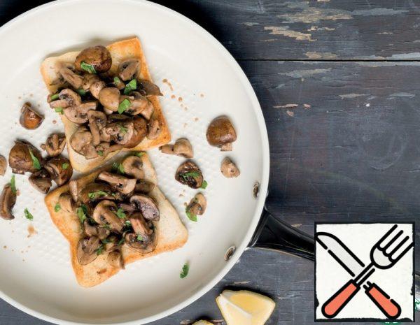 Heat the oil in a frying pan and fry the mushrooms with garlic. Season with salt and pepper. Set aside in a separate container.
Fry the bread in oil until Golden brown.
Put a generous portion of mushrooms on each toast. Garnish with parsley and lemon wedges.