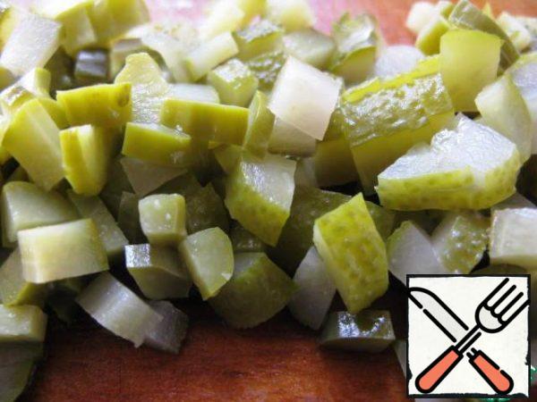 Chop olives, capers and pickled cucumbers.