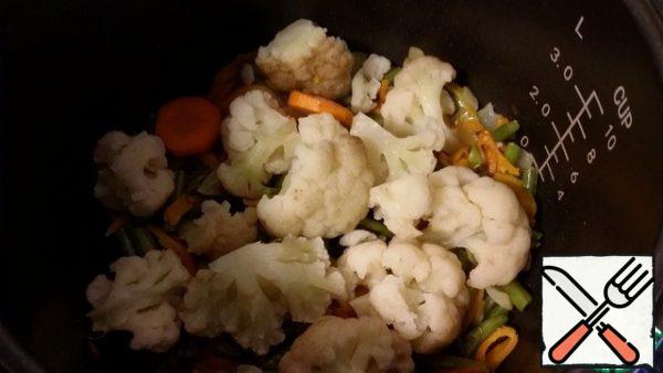Then add the cauliflower disassembled into inflorescences. Fry everything together for 5 minutes. Add salt and spices.