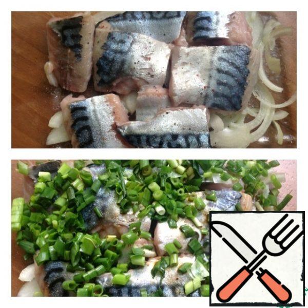 Cut the mackerel into fillets and cut into small pieces. Grease the baking dish with vegetable oil and put the onion cut into thin half rings on the bottom. Put the fish on top. Sprinkle with lemon juice, salt and pepper. Finely chop the green onions and put them on the fish, season with soy sauce on top.