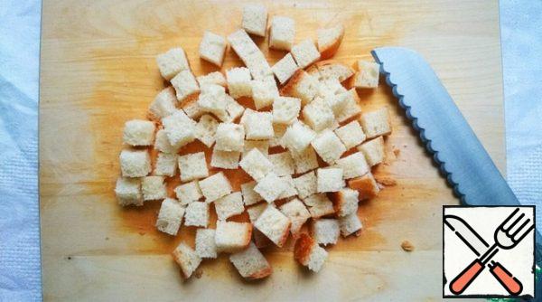 Bread is cut into cubes, the thickness can be any, but the smaller the cubes, the faster the crackers will be ready.