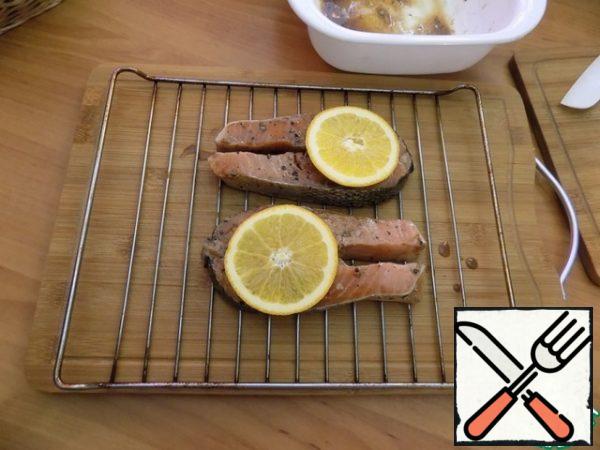 Turned on the grill in the electric oven. You can do it in a regular oven. Heat the oven to t-200C. Put the fish pieces on the grill from the oven. Put one thin slice of orange on each piece. Put in the oven for 15 minutes. We substitute a tray under the grate, the juice will drip from the fish. Be guided by your oven.