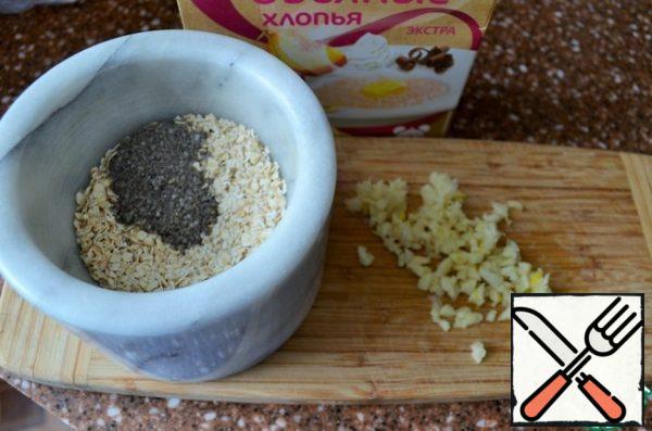 Chop the garlic, grind the oat flakes, and
add salt. Mix everything together.