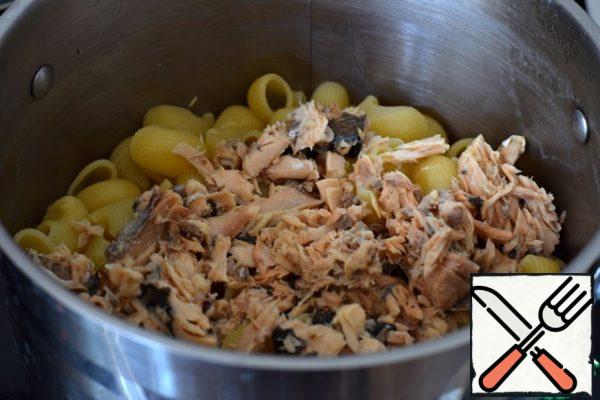 Drain the water from the shells, leaving 150 ml of water in which the paste was cooked.
With canned fish (pink salmon, tuna, trout), drain the liquid and lightly mash them with a fork. Put the canned food in a saucepan with the pasta. Stir.