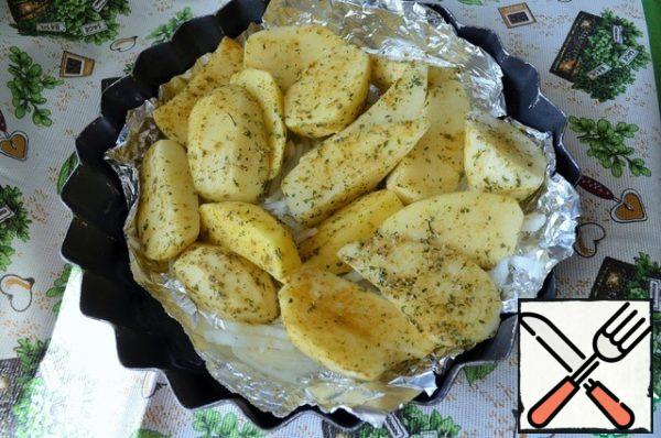 Peel the onion and cut it into feathers.
Put it in a mold, pour in the oil.
Wash the potatoes, peel and cut into 4-6 pieces.
Wash, dry, roll in dry herbs, curry, lightly salt.
Put it on the onion.
Put in the oven and bake for 15-20 minutes at 180 degrees C.
I cover the bottom with thick foil, this will save you from unnecessary work.