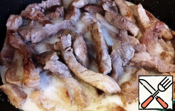 Then add the milk to the meat and reduce the heat to low.