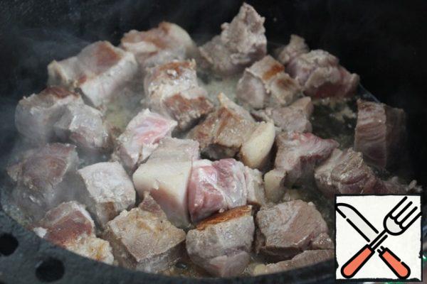 Grease the cauldron with vegetable oil, heat it and fry the meat in 2 steps to a crust.