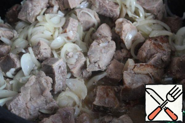 Return all the meat to the cauldron, add the onion cut into half rings, mix everything, set the minimum heat and leave under the lid for 40 minutes.