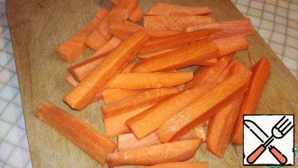 Carrots are cut into long bars and spread on top of the meat.