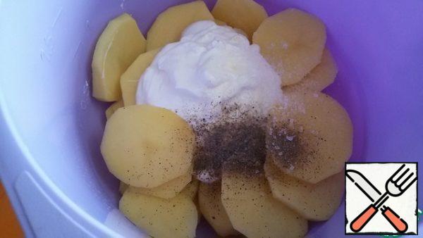 Peel the potatoes and cut them into 5-6 mm thick slices. Add 2 tbsp sour cream, salt and black pepper.