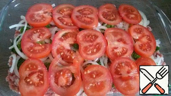 And continue - a layer of onions, and then tomatoes.
