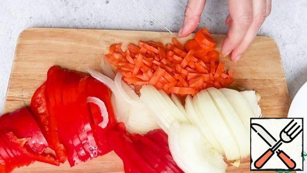 Cut the bell pepper, onion, and carrot into strips.