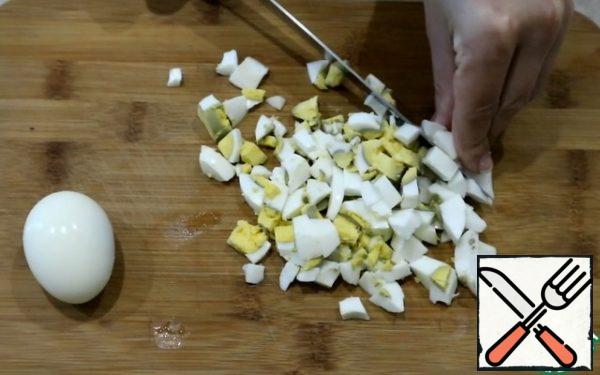 Cut two eggs into cubes, and cut one into four pieces for decoration.