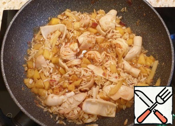 Add the seafood and seasoning and fry for 3 minutes. Add the rice and stir.