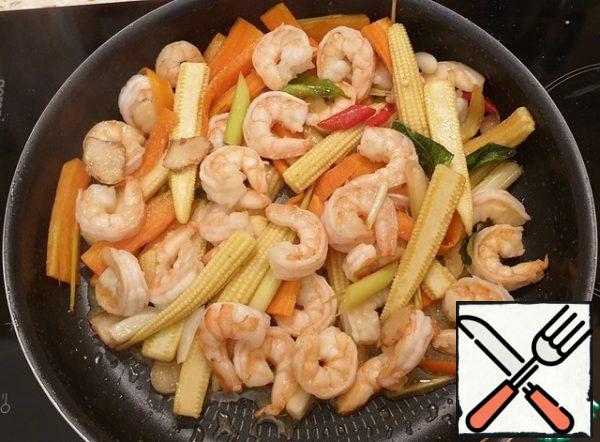 Add the shrimp and garlic. Salt. Fry the prawns for a couple of minutes on each side (the prawns should turn pink, but do not overdo it). You can serve it with Thai sweet chili sauce.