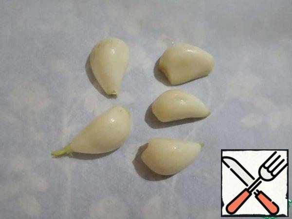 Garlic is cleaned, spread on parchment paper, lightly lubricate with vegetable oil and bake in the oven for 25-30 minutes (time - optional).
