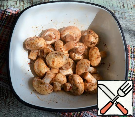 Wash the mushrooms, dry them, mix them with adzhika, and leave them.