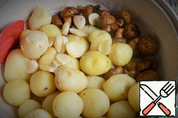 Heat the oil, fry the onion feathers, add the mushrooms.
Fry for 5-8 minutes, medium heat, stirring. Then add the potatoes and garlic petals.