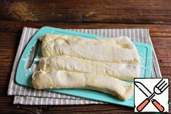 Cut the dough layer into 4 parts lengthwise.
