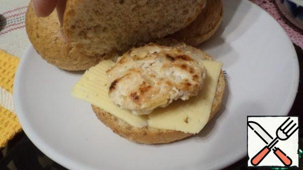 Cut the buns, but not to the end, 0.5 cm short of the edge on one side. Put the cheese and cutlets on the rolls.