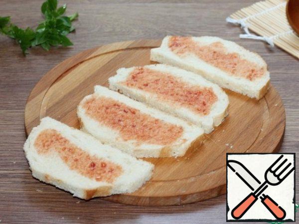 Slices of bread smeared with ketchup.