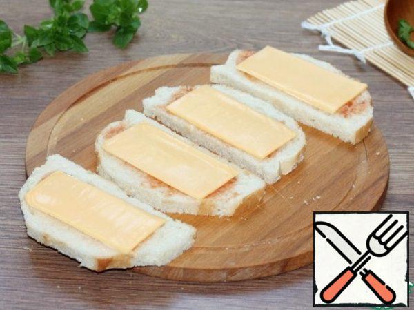 Put a slice of cheese on the bread. You can take the cheese melted into the plates or solid plates. Plates previously, I cut into 2 parts.