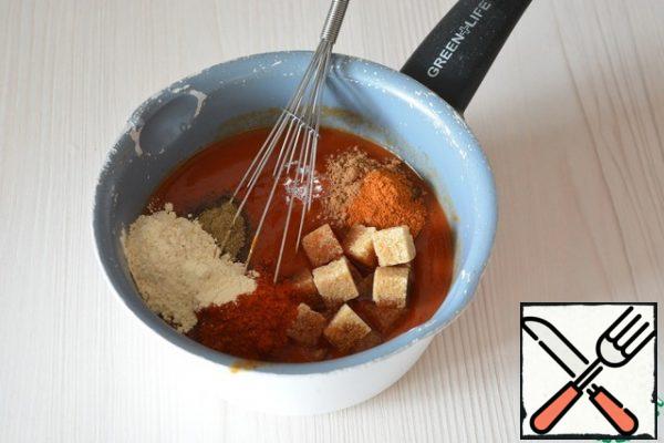 Dilute the tomato paste with water, add salt, sugar, all the specified spices and whisk everything into a homogeneous mass, put on fire.