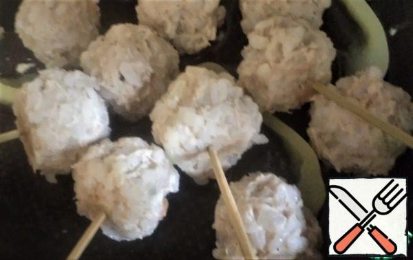 In hot hedgehogs stick skewers, put them at a distance from each other and sprinkle with grated cheese and sesame seeds.