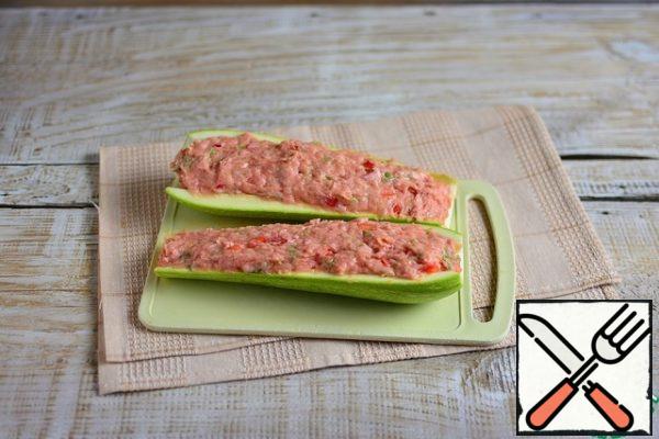 Wash the zucchini, cut in half lengthwise, remove the core with the seeds, forming boats, stuff with minced meat, flatten tightly.