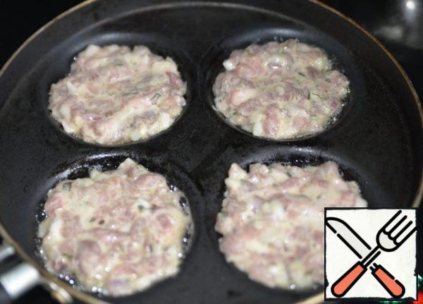 Pour the oil into a hot frying pan and spoon the minced Turkey. It is desirable that the cutlets are the same diameter as the bun in which we will "sculpt" the hamburger. But I did it in a pan for pancakes, so the cutlets are more or less even, but the diameter was smaller.