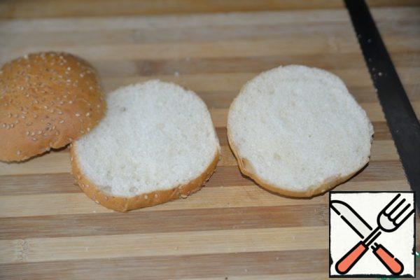 We take a hamburger bun, I have a ready-made one with sesame seeds. With a knife (preferably with a file), cut lengthwise into three equal parts.