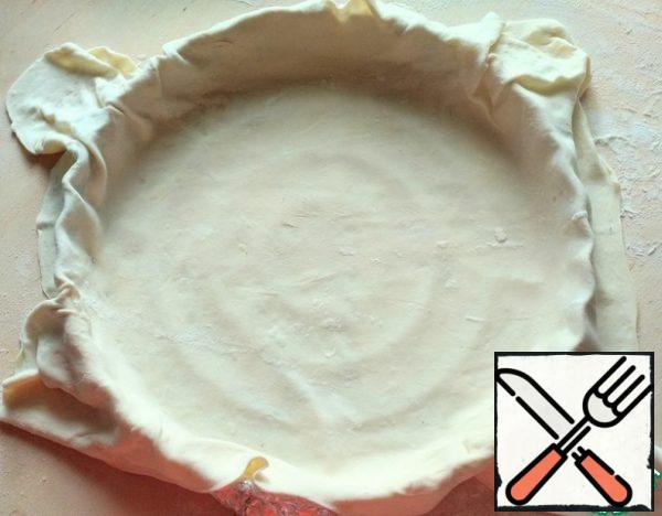 The number of ingredients is calculated for 2 pizzas with a diameter of 28-30 cm. Pre-defrost the puff pastry and roll it out as thinly as possible. If necessary, cover the baking dish with foil or parchment, cover with dough on top, so that the edges hang down a little.