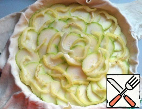 Wash the pepper, peel the seeds, cut into circles and spread on top of the zucchini.