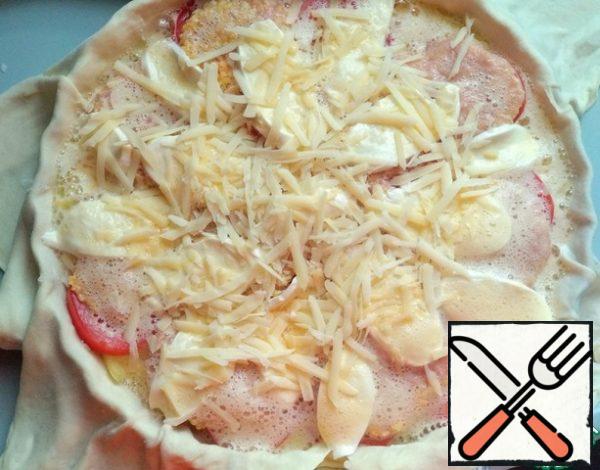 Fill the pizza with egg mass. Grate the cheese on a coarse grater on top.