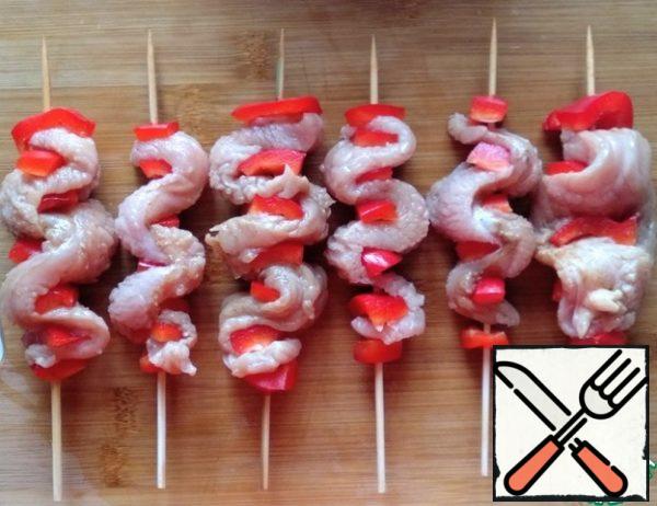 On wooden skewers, snake the Turkey with pepper.