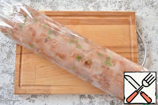 Cover the eggs with the remaining minced meat. Roll everything into a tight roll and secure the edges of the film.