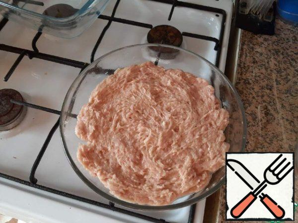 Minced meat on the entire surface is leveled in a baking dish.