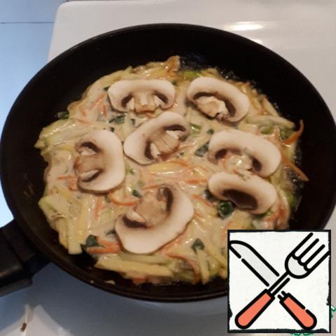 Pour 1 tablespoon of vegetable oil into the pan and put half of the vegetable mass, cut the mushrooms into slices and put them on top. Fry over medium heat. The diameter of the pancake is 18 cm. Do not cover with a lid!