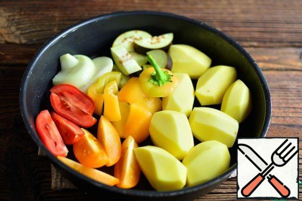 Peel the potatoes, tomatoes, onions, eggplant and pepper and chop them coarsely. Put all the vegetables in a baking dish.