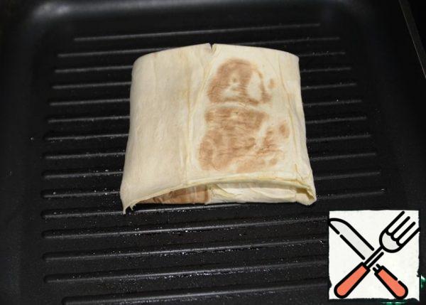 I baked it at home on a grill pan. The pan can be greased with oil, or you can dry it. Put the envelope "seam" down on a hot pan.