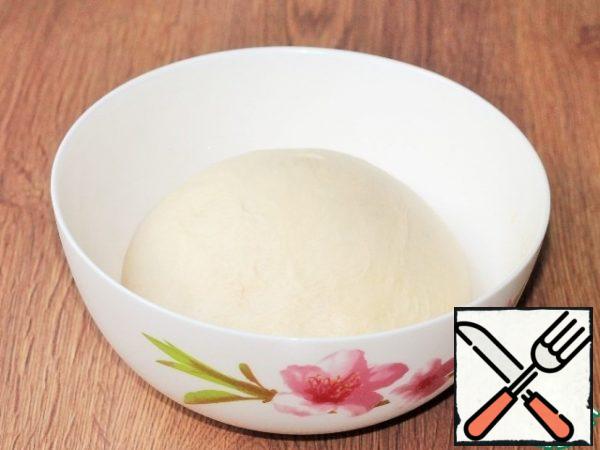 Forming a pie. The dough that comes up is crushed and covered with a towel, give it 20 minutes for a slight rise.