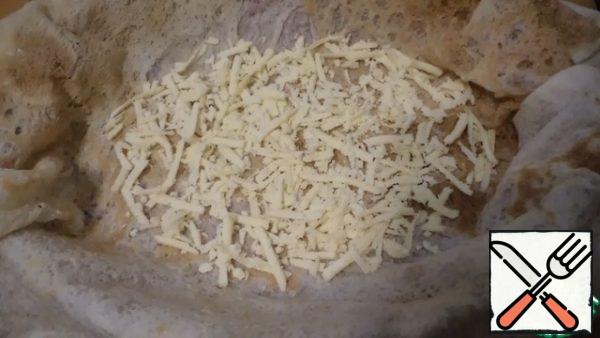 Spread the first layer - grated cheese.