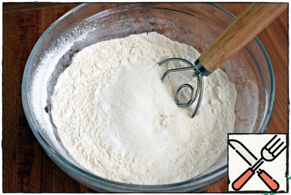 Combine the sifted flour with salt, soda, and sugar. Mix everything together.